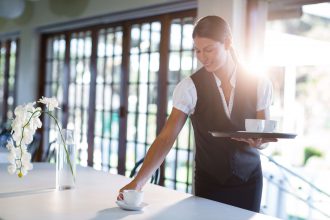 waitress clearing table in hotel dining room