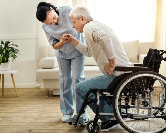 healthcare worker helping man out of wheelchair