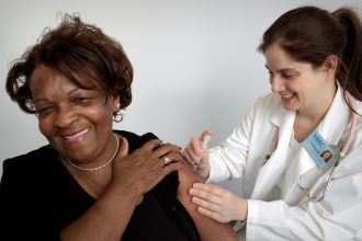 smiling doctor injecting smiling woman