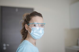 woman in blue shirt wearing facemask