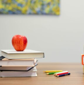 stack of books with apple on top