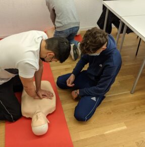 man teaching boy CPR